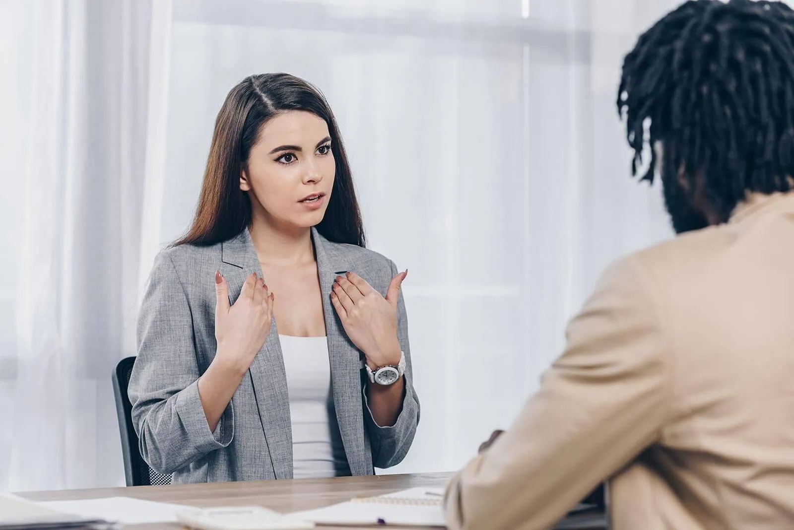 An employee explaining a pay problem across a desk