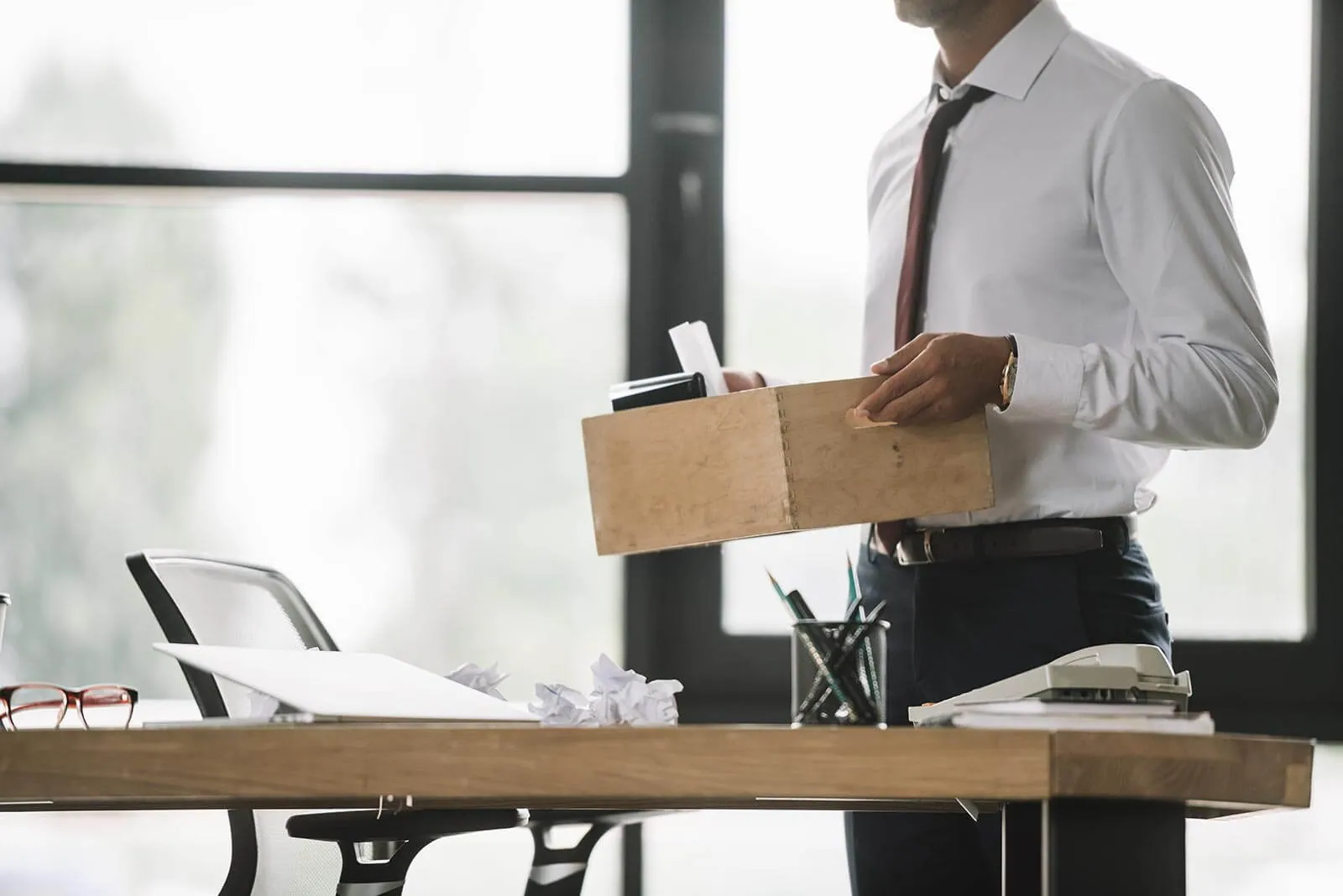 An employee packing a desk into a cardboard box